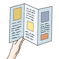 Eine Hand hält ein Faltblatt.