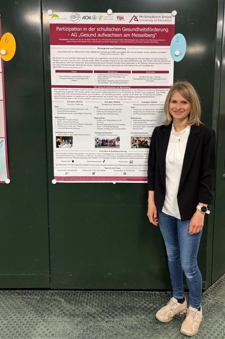 Leiterin Meike Funk vor dem Plakat "Gesund aufwachsen am Messelberg"