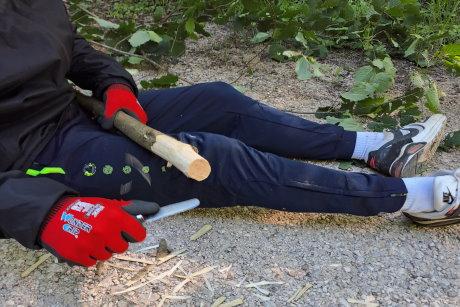 Schulkind beim Schnitzen eines Astes