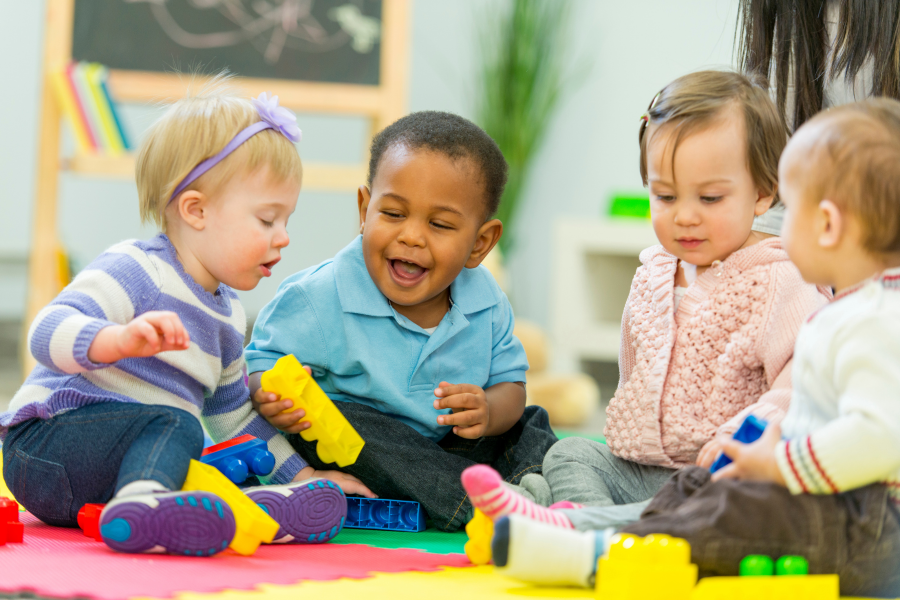Eine Gruppe Babys spielt mit Legosteinen Eine Gruppe Babys spielt mit Legosteinen