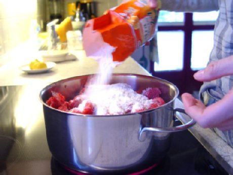 Marmeladenherstellung Gelierzucker wird zu Himbeeren in einen Topf gegeben