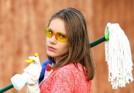 Junge Frau mit cooler Sonnenbrille und Putzmitteln