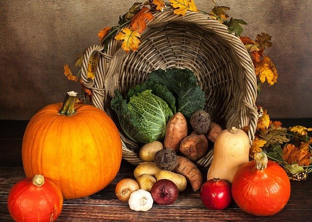 Herbstgemüse vor einem Flechtkorb 