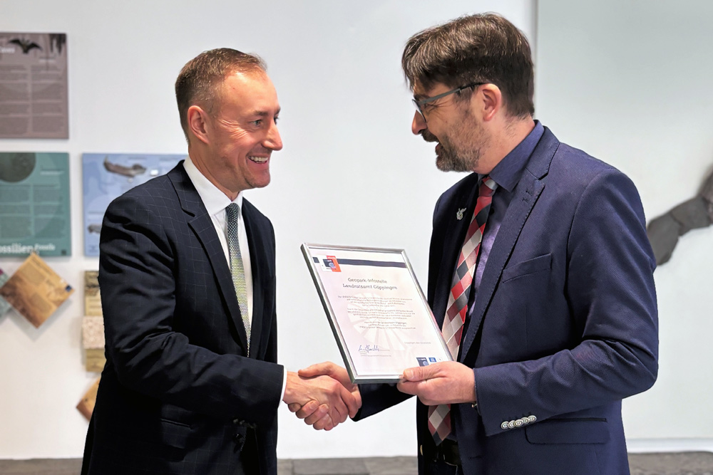 Einweihung Geopark Infostelle Landrat Möller links im Bild übernimmt eine Urkunde von Bürgermeister Rucks links im Bild.