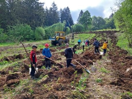 Kinder graben Pflanzlöcher für Kartoffeln