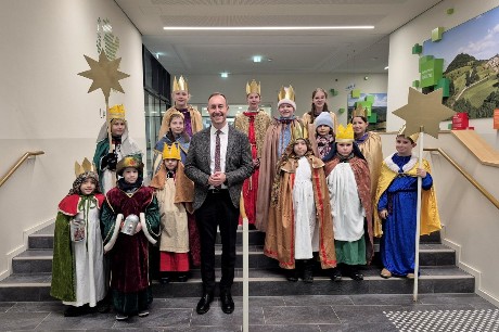 Eine Gruppe von Kindern, kostümiert als Sternsinger, mit Landrat Markus Möller in der Mitte.