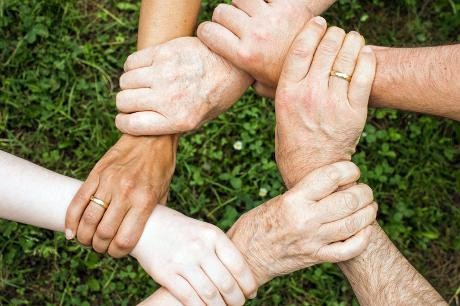 Hände fassen sich gegenseitig als Symbol für Gemeinschaft.