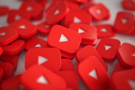 Logos der Video-Plattform YouTube liegen auf einem Haufen