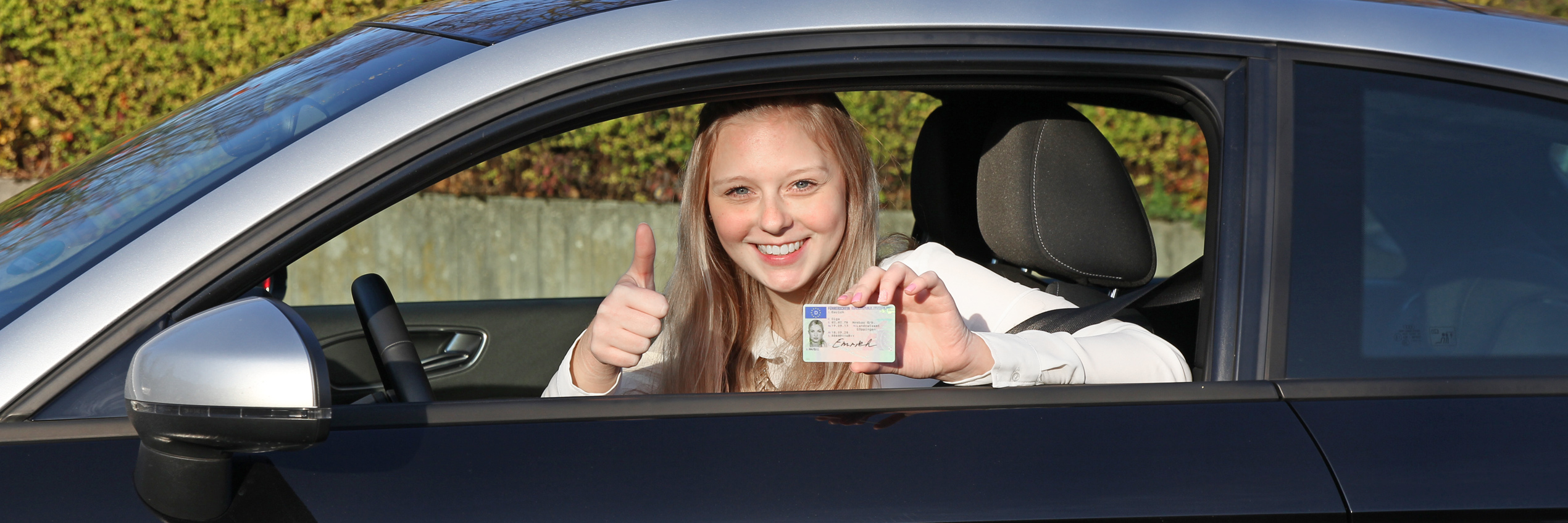 Alles klar mit dem EU-Führerschein Junge Frau zeigt ihrem Kartenführerschein