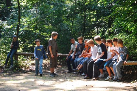 Jugendgruppe Gruppe Jugendlicher auf einer Bank im Wald