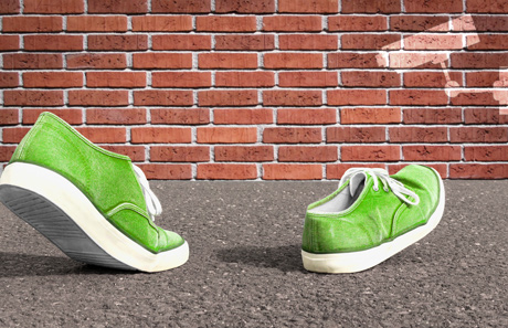 Symbolbild: Schuhe vor Backsteinmauer