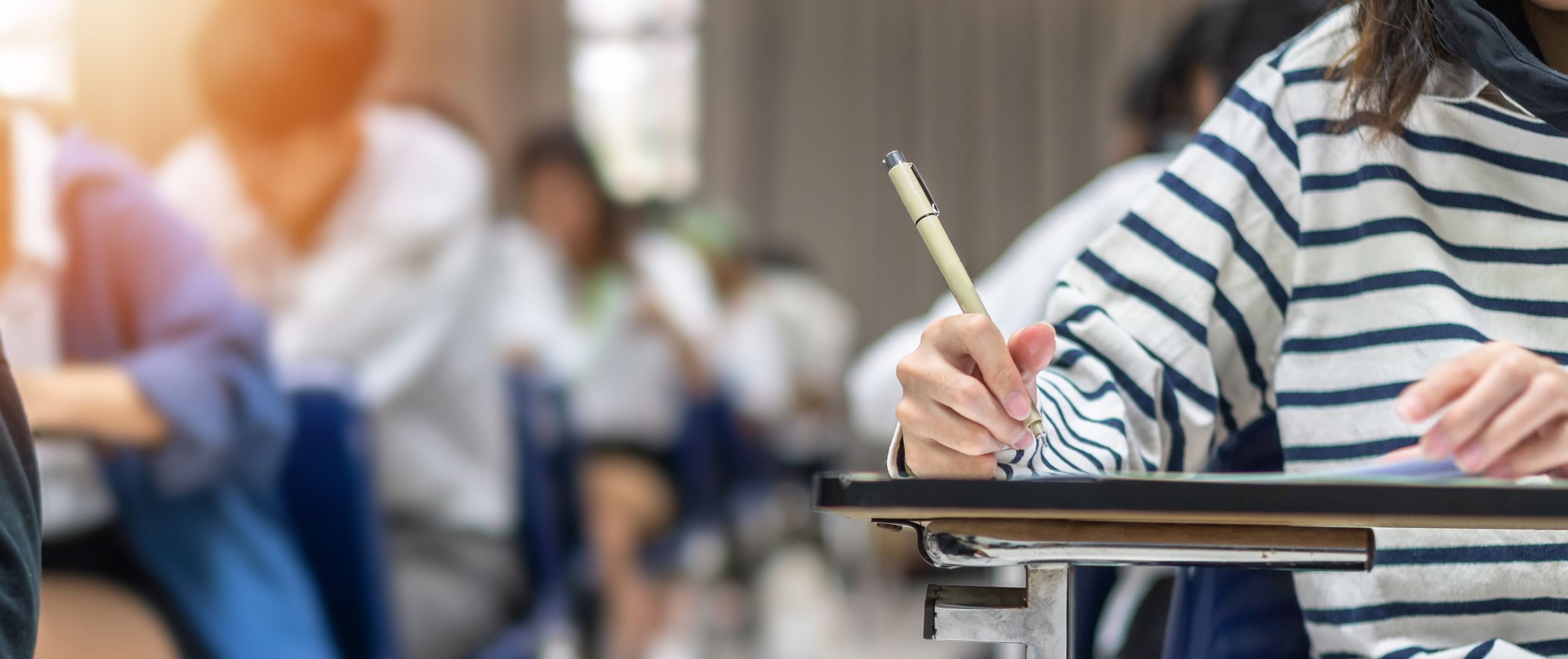 Schulklasse Kinder sitzen in der Schule und schreiben.