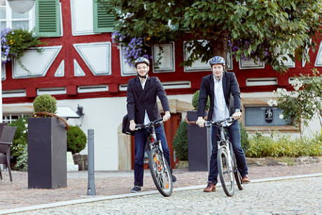 Herren im Anzug auf Fahrrädern